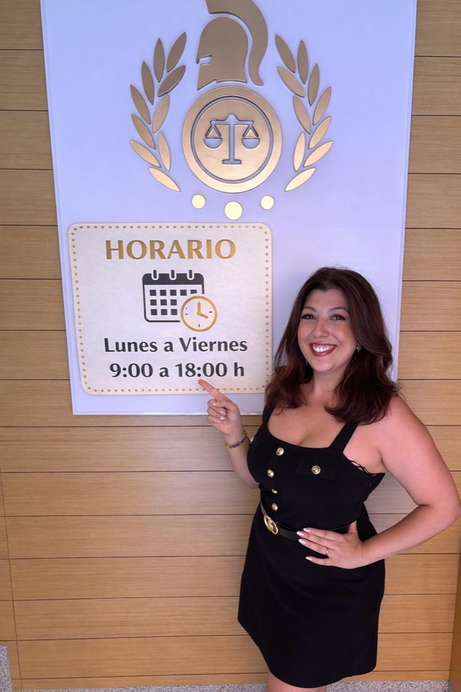 Josefa Salazar Salazar en el despacho, junto al horario de atención: lunes a viernes de 9:00 a 18:00